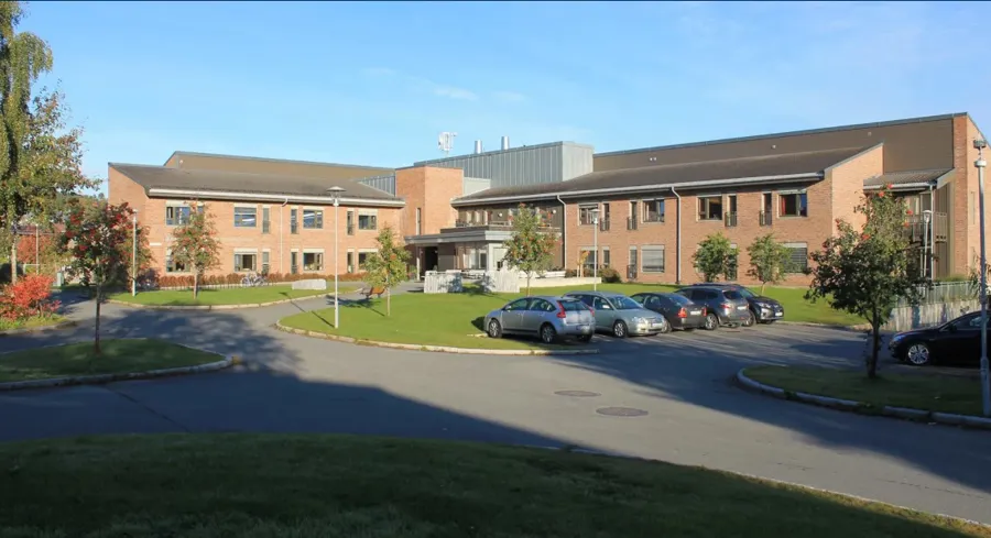 En parkeringsplass foran en stor bygning.