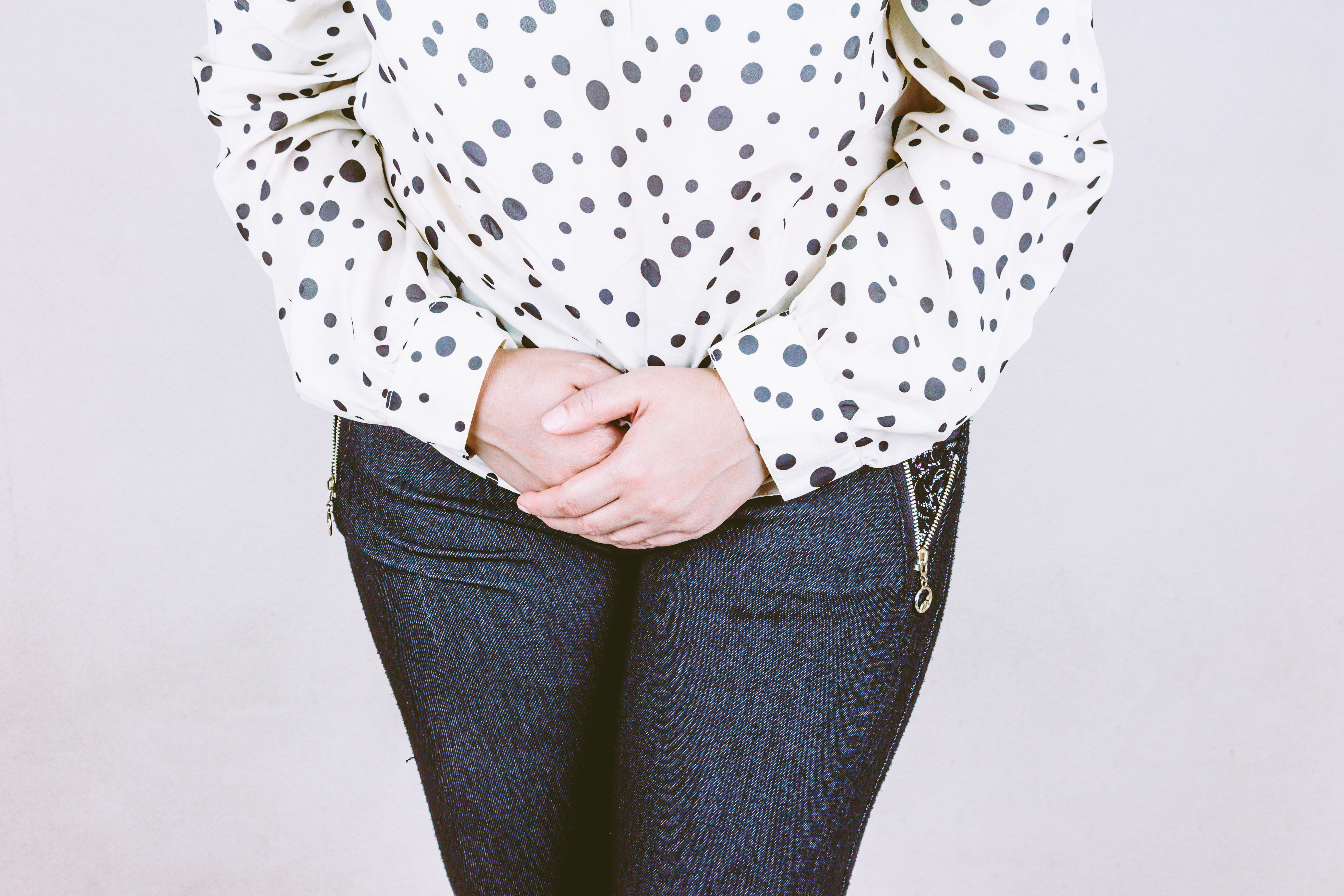 Dame som holder hendene samlet på magen