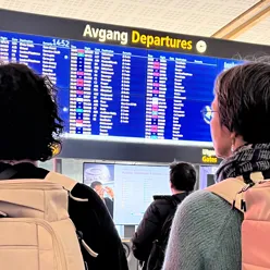 Personer som ser på en informasjonsskjerm