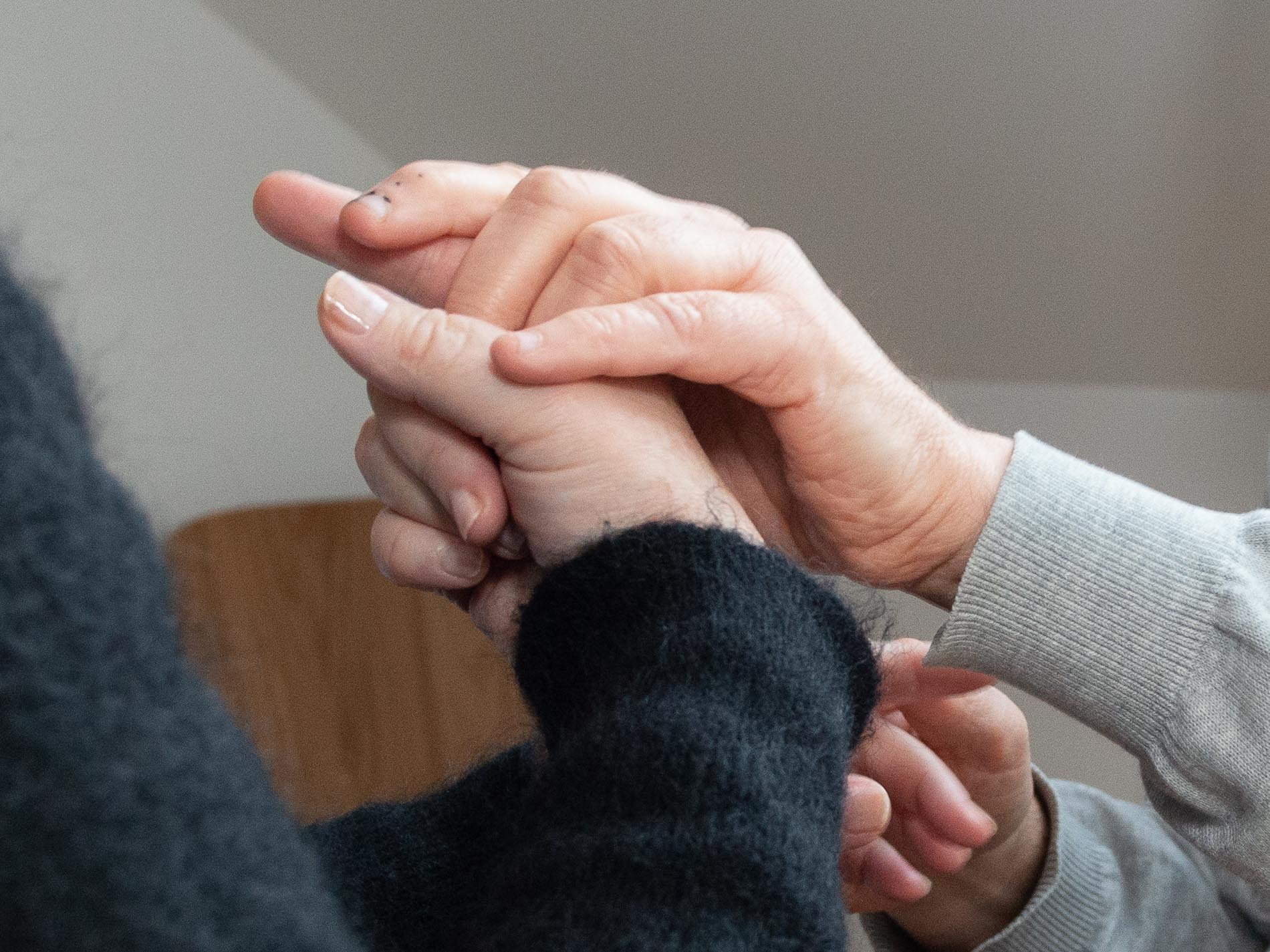 Et nærbilde av hender som holder i hverandre