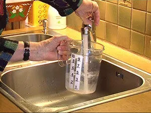 En person som heller en væske i en flaske